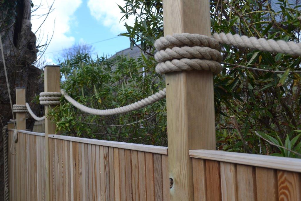 Wooden fence with synthetic hemp rope against a natural background