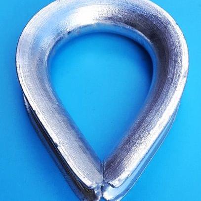 Heart shaped galvanised metal thimble for rope with a blue background