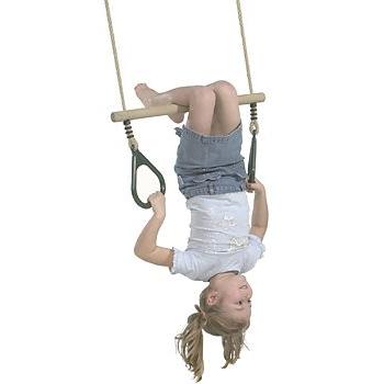 Child hanging upside down from a trapeze with plastic rings on a white background