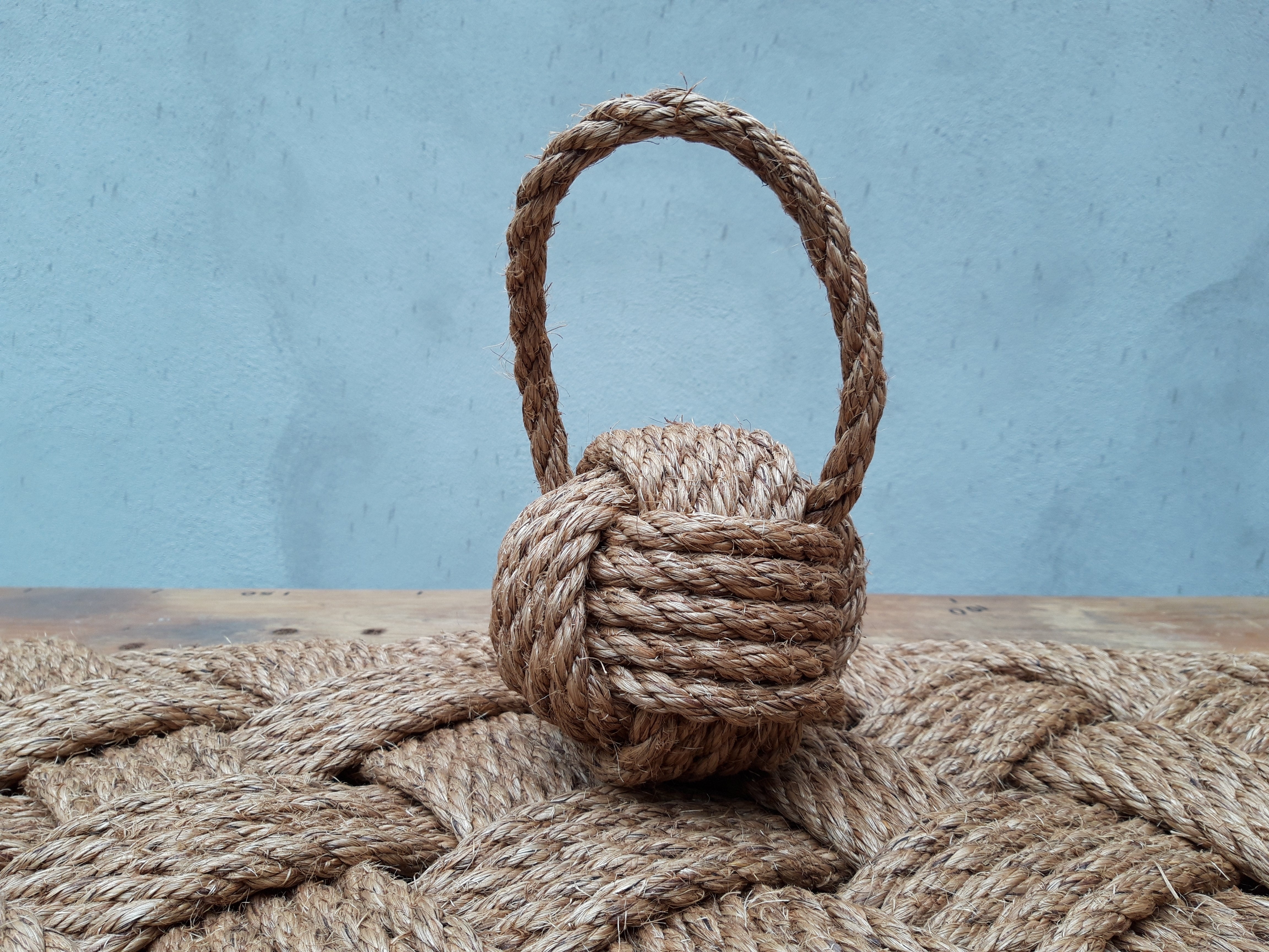 12mm manila rope doorstop on a rope doormat with a blue background
