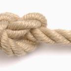 Close-up of a knotted 3-strand classic polyester rope on a white background