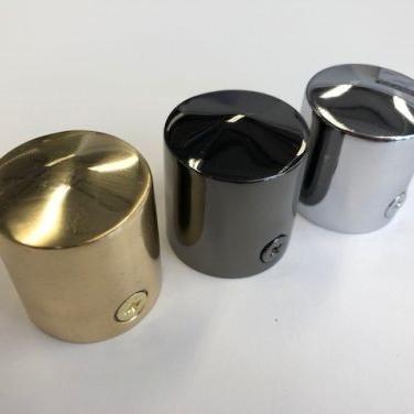 Three brass cap ends for rope in gold, black, and silver on a white background